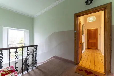 a hallway with a staircase leading to a door at Ochil View in Stirling