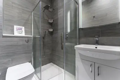 a bathroom with a shower and a toilet and a sink at Ochil View in Stirling
