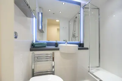 a bathroom with a toilet and a sink and a mirror at Student Only Ensuite Room in Central Glasgow in Glasgow