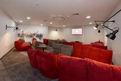 a living room with red couches and a screen at Student Only Ensuite Room in Central Glasgow in Glasgow