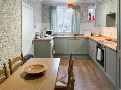 a kitchen with a table and a sink and a counter at Bay View in Oban