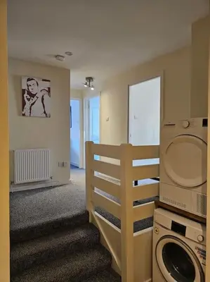 a laundry room with a washing machine and a staircase at 2 Bedroom Modern stylish Apt in Glasgow City Centre in Glasgow