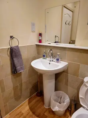 a bathroom with a sink and a toilet and a mirror at 2 Bedroom Modern stylish Apt in Glasgow City Centre in Glasgow