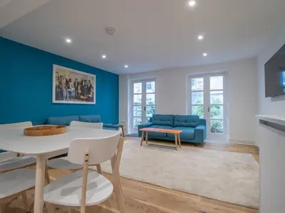a living room with blue walls and a table and chairs at Stylish West End Detached Mews - Pass the Keys in Glasgow