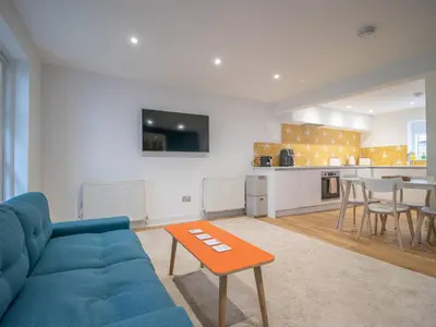 a living room with a blue couch and a table at Stylish West End Detached Mews - Pass the Keys in Glasgow