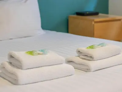 three towels sitting on top of a bed at Stylish West End Detached Mews - Pass the Keys in Glasgow