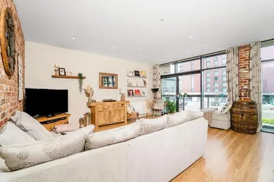 a living room with a white couch and a tv at Luxury Huge Modern Open Plan 2Bedroom Flat - Free Private Parking & Balcony located at the OVO Hydro and SEC Centre in Glasgow