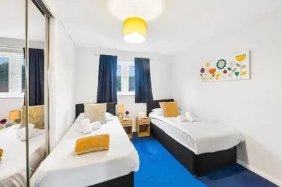 a room with two beds and a mirror at PREMIER - Maryhill Apartment in Glasgow