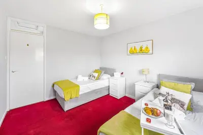 a bedroom with a bed and a table with a bowl of fruit on it at PREMIER - Maryhill Apartment in Glasgow