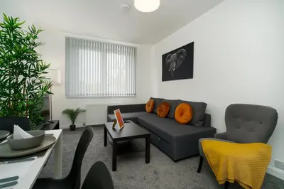 a living room with a couch and a table at Free Parking - 2 Bedroom Flat-by Holiday Homes in Cambusnethan