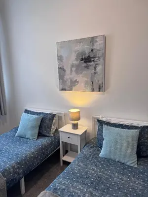 a room with two beds and a table with a lamp at Ben Lomond Apartment - Macaulay Letting in Alexandria