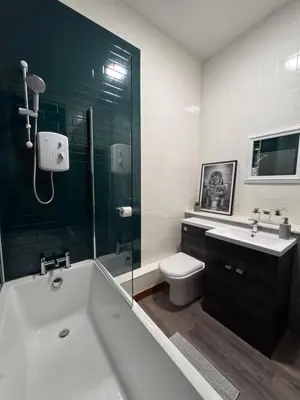 a bathroom with a tub and a toilet and a sink at Ben Lomond Apartment - Macaulay Letting in Alexandria