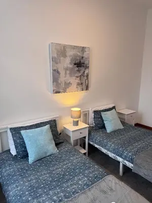 a room with two beds and a table with a lamp at Ben Lomond Apartment - Macaulay Letting in Alexandria