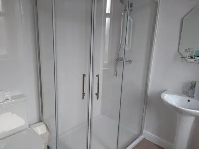 a bathroom with a shower and a toilet and a sink at Dalgair House Hotel in Callander