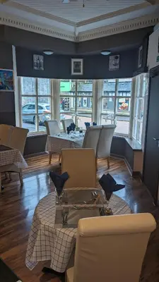 a room with chairs and a table and windows at Dalgair House Hotel in Callander