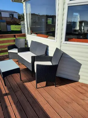 a porch with two chairs and a table and a window at Bunny View in Kirkcowan