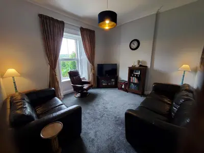 a living room with two leather couches and a television at McCaig's View in Oban
