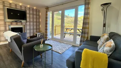 a living room with a couch and a tv and a table at Jura in Oban