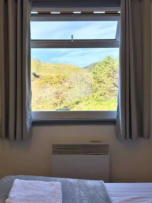 a bedroom with a window with a view of a hill at Jura in Oban