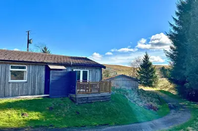 a small house with a deck in the grass at Jura in Oban