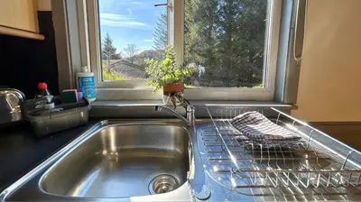 a kitchen sink with a window and a dish drying rack at Jura in Oban