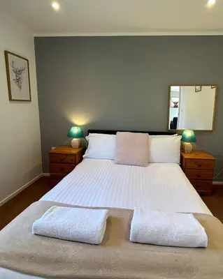 a bedroom with a large bed with two pillows on it at Skye in Oban