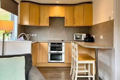 a kitchen with wooden cabinets and a counter top at Skye in Oban