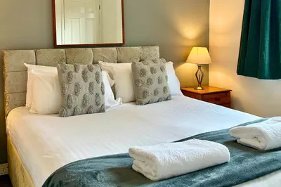 a bedroom with a large bed with white sheets and pillows at Rum in Oban