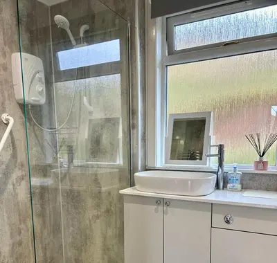 a bathroom with a shower and a sink and a window at Rum in Oban