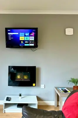 a living room with a flat screen tv on a wall at Rum in Oban