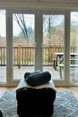 a couch with pillows on it in front of a sliding glass door at Rum in Oban
