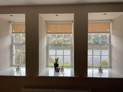 three windows in a room with a potted plant at Craigruie Farmhouse in Balquhidder