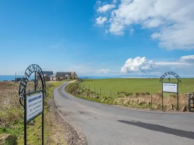 a road with two signs on the side of it at Eryb Cottage - Uk46883 in Kilmory