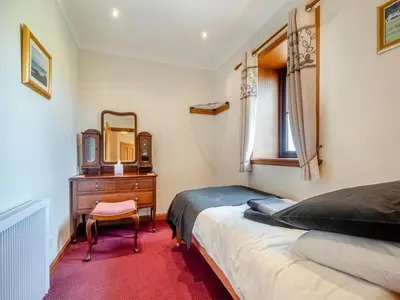 a bedroom with a bed and a dresser and a mirror at Eryb Cottage - Uk46883 in Kilmory