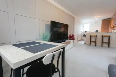 a kitchen and living room with a table and chairs at Whiteside Apartment in Bathgate