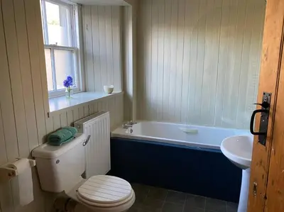 a bathroom with a toilet and a tub and a sink at Christmas Cottage in Balmaha