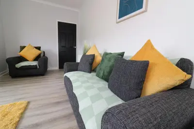a living room with a couch and two chairs at Signature - Huntley House in Glasgow