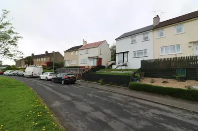 a street with houses and cars parked on the street at Signature - Huntley House in Glasgow