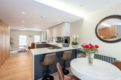 a kitchen with a table with a vase of flowers on it at Dragon Suites - City Centre 2 Bed Luxury Mews House in Edinburgh