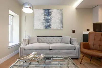 a living room with a couch and a glass table at Dragon Suites - City Centre 2 Bed Luxury Mews House in Edinburgh