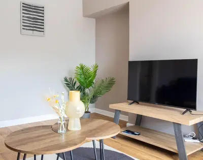 a living room with a tv and a table at Burns House in Livingston