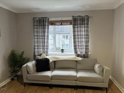 a living room with a couch in front of a window at Burns House in Livingston