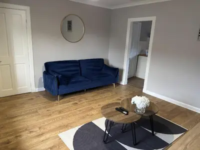 a living room with a blue couch and a table at Burns House in Livingston
