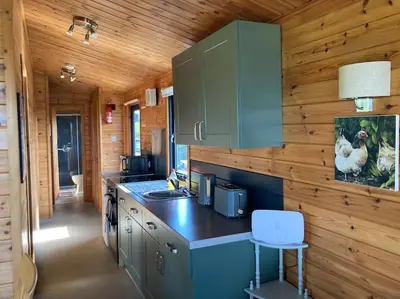 a kitchen in a log cabin with a counter top at The Lodge at Blackhill Farm in Carluke