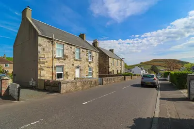 a car driving down a street next to a building at Meadowfoot Haven in West Kilbride