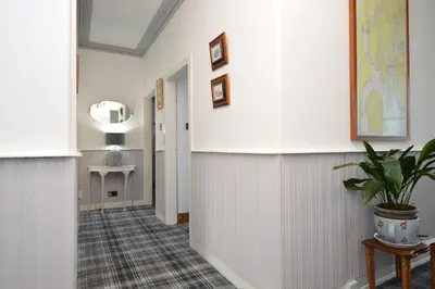 a hallway with white walls and a potted plant at Janeville Holiday Apartment in Ardrishaig