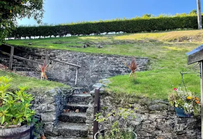 a set of stone stairs with plants on a hill at Janeville Holiday Apartment in Ardrishaig