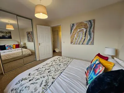 a bedroom with a large bed and a mirror at 2 Bed Apt, 4 beds with Parking in Edinburgh