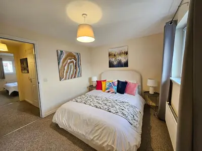 a bedroom with a bed with colorful pillows on it at 2 Bed Apt, 4 beds with Parking in Edinburgh