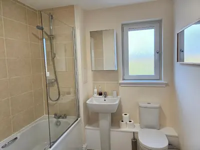 a bathroom with a toilet and a sink and a shower at 2 Bed Apt, 4 beds with Parking in Edinburgh